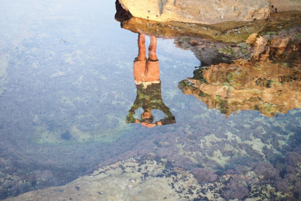 Reflection of a man in rockpool - Australian Stock Image