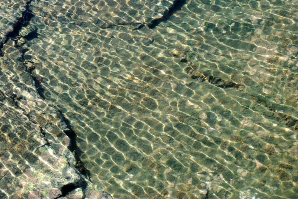 Reflection of sunlight in the water in a rock pool - Australian Stock Image