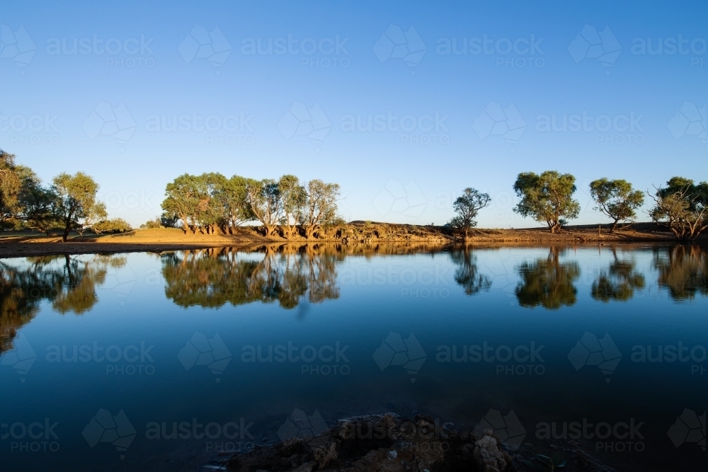 reflections on a dam under a blue sky - Australian Stock Image
