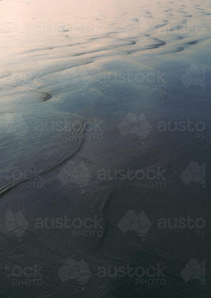 Reflective patterns on shallow water at beach - Australian Stock Image