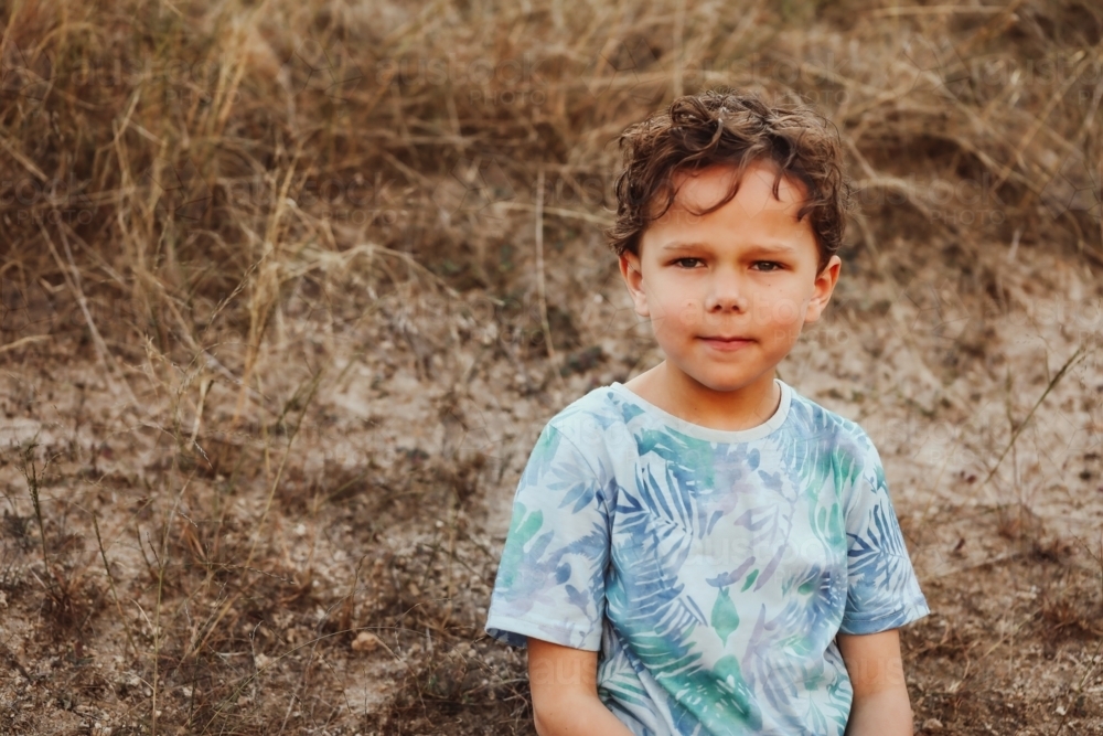 Relaxed Aboriginal boy in the Australian bush with copy space - Australian Stock Image