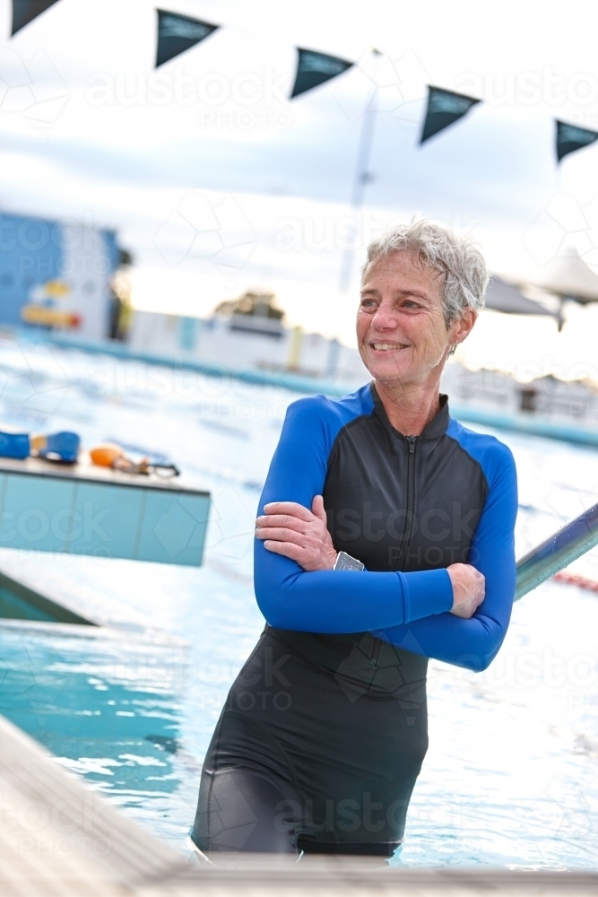 Relaxed active senior lady at swimming pool - Australian Stock Image