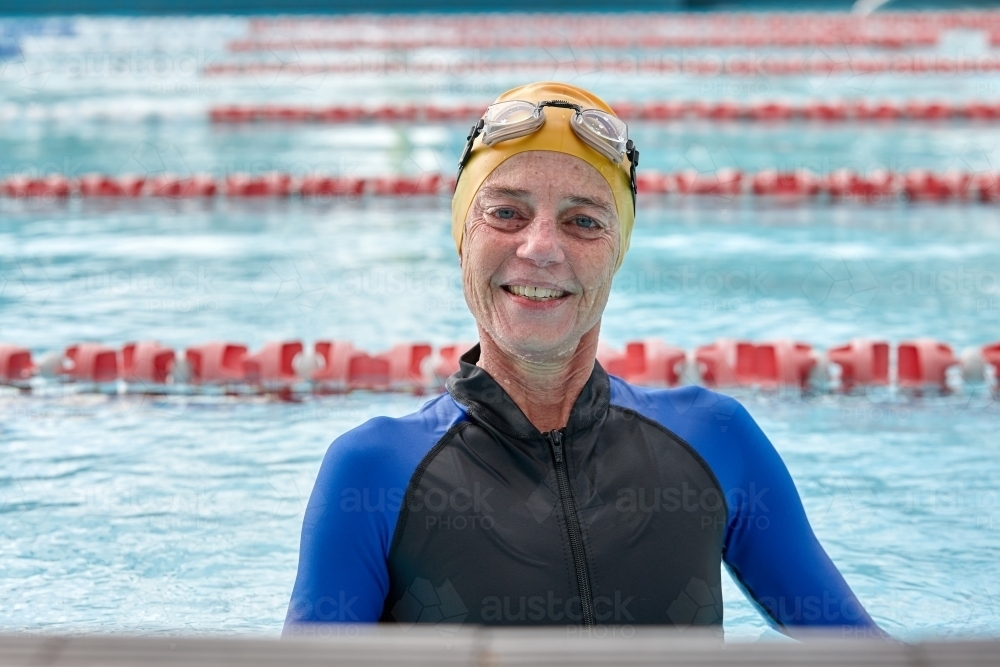 Relaxed active senior lady at swimming pool - Australian Stock Image