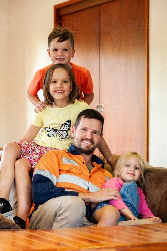Relaxed tradie hanging out with his son and daughters - Australian Stock Image