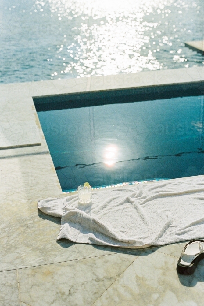 Relaxing summer day by the pool with a drink - Australian Stock Image