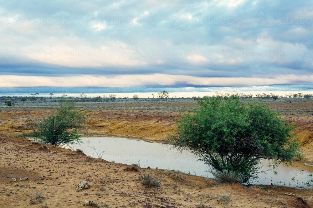 Remote barren landscape with small dam - Australian Stock Image