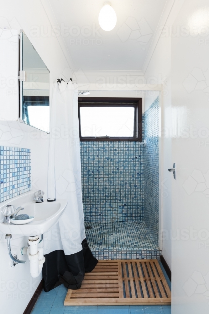 Retro blue mosaic tiled shower bathroom in Australian holiday house - Australian Stock Image
