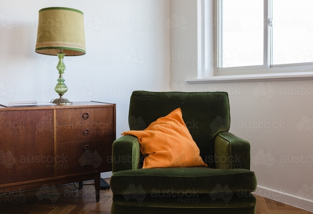 Retro living room furniture of a green velvet armchair and mid century buffet - Australian Stock Image