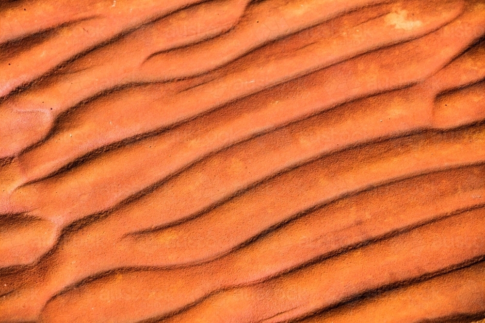 Rippled textured red rock that naturally occurs in Central Australia from when there was an inland s - Australian Stock Image