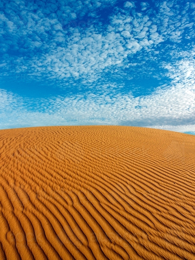 Ripples in a sandhill against blue sky - Australian Stock Image