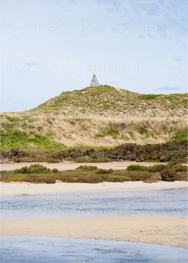River mouth with hill and trig point in background - Australian Stock Image