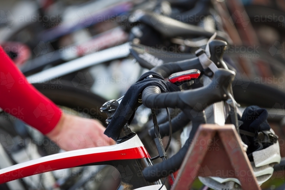 Road bikes on a rack with cyclist in background - Australian Stock Image