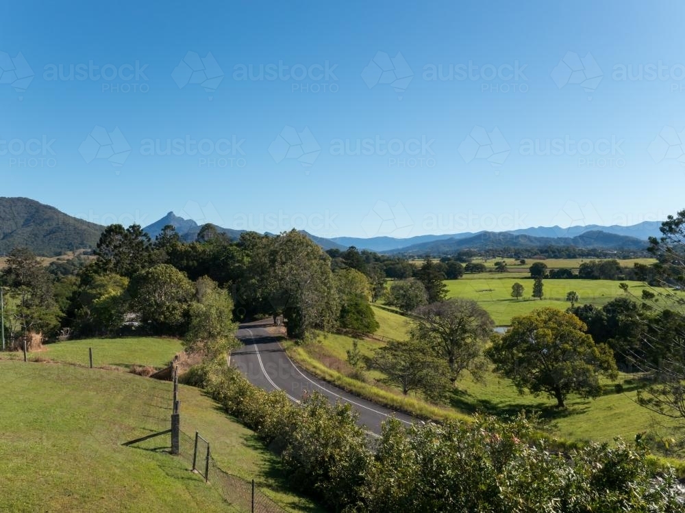 Road curving through a green fertile valley - Australian Stock Image
