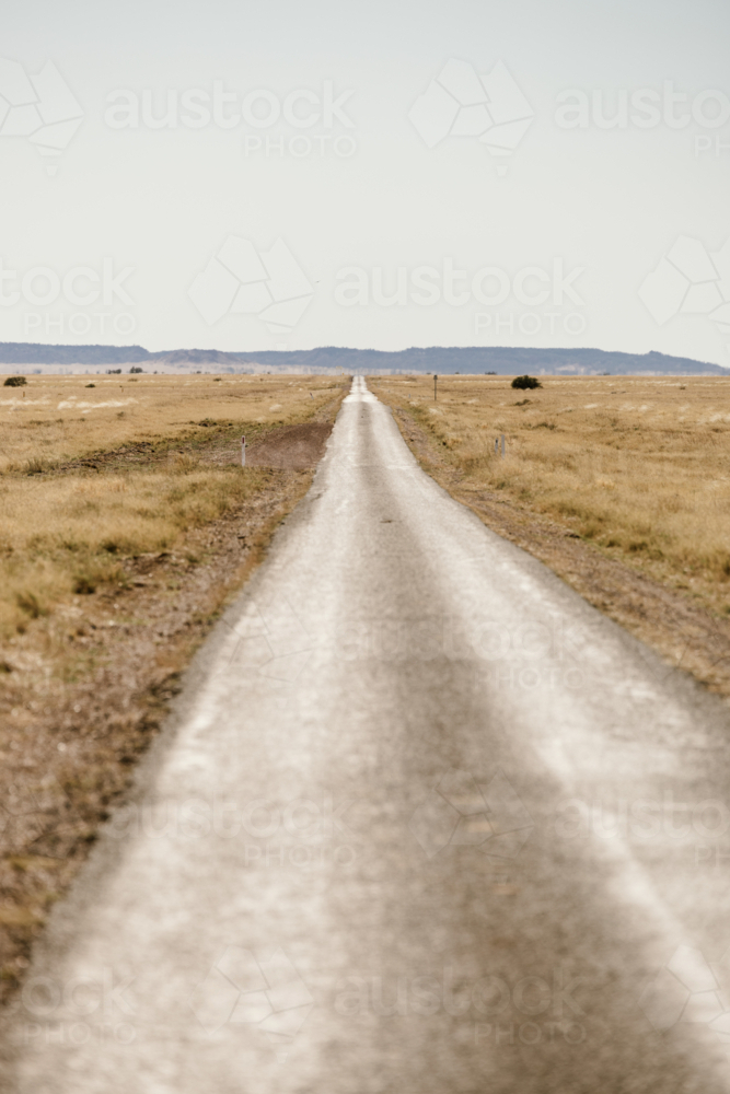 Road in the outback heading towards hills - Australian Stock Image