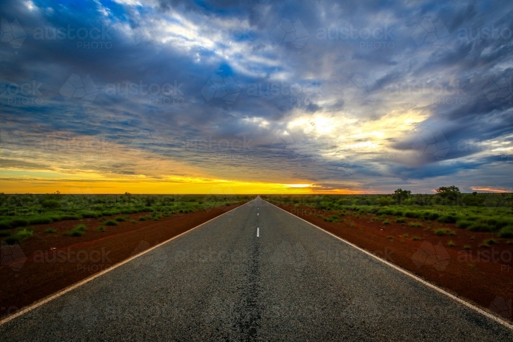 Road leading to horizon with dramatic sky - Australian Stock Image