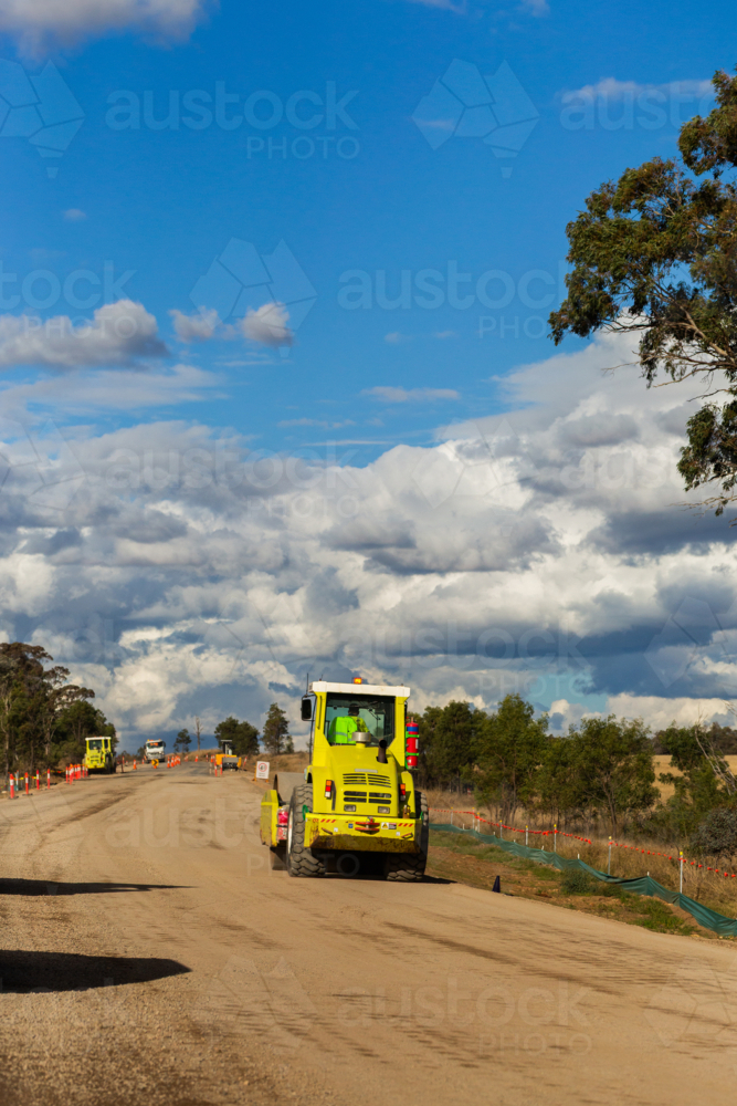 road resurfacing earthworks machinery on worksite beside rural highway - Australian Stock Image