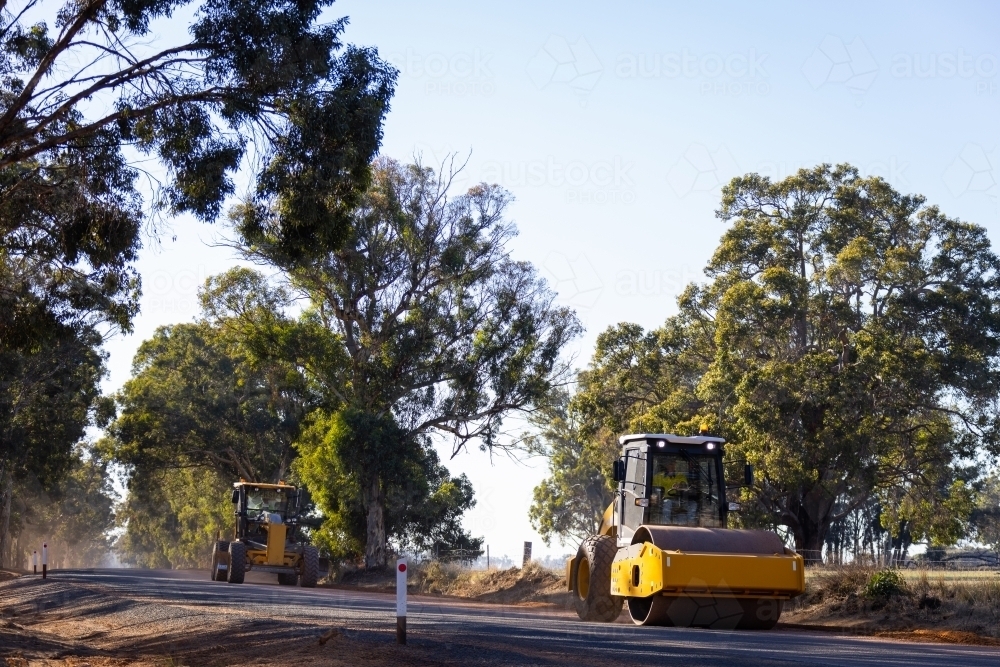 road roller and grader working on country road - Australian Stock Image