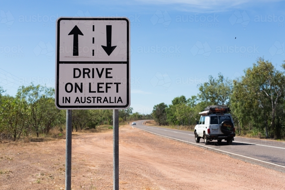 Road sign about driving on the left with a 4 wheel drive in the background - Australian Stock Image