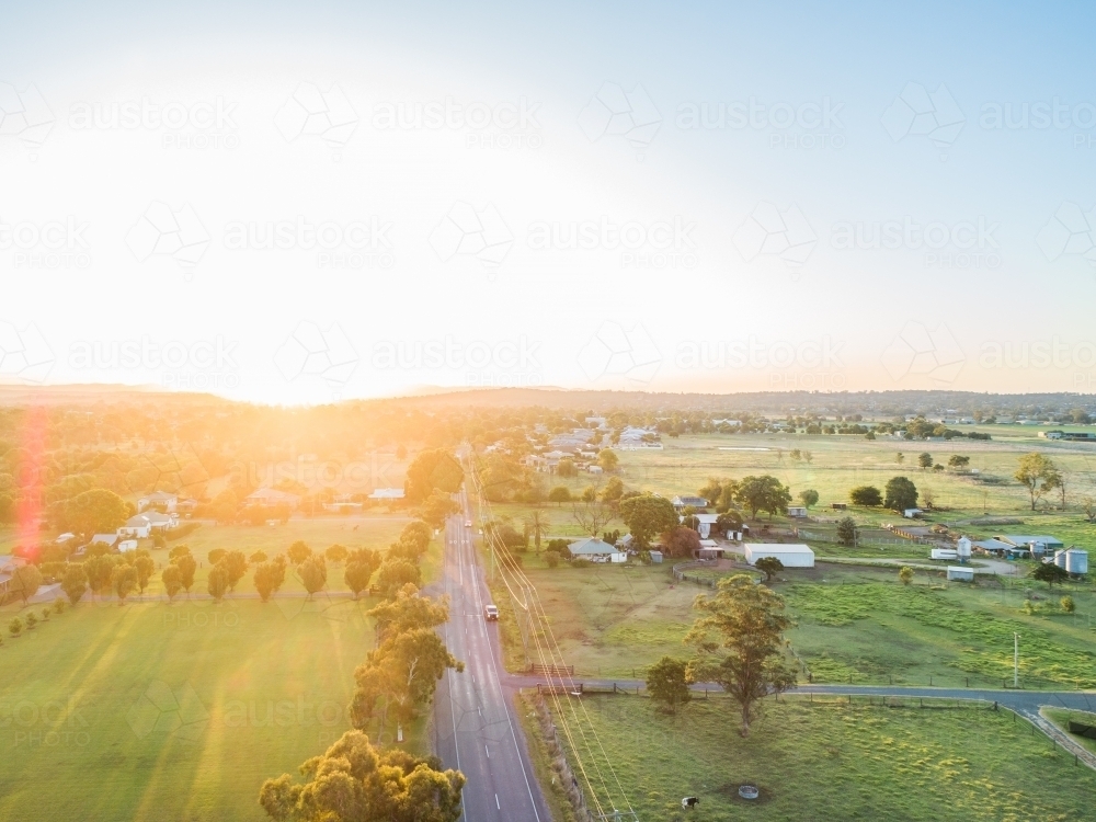 Road to the sunset in australian countryside with rural town - Australian Stock Image
