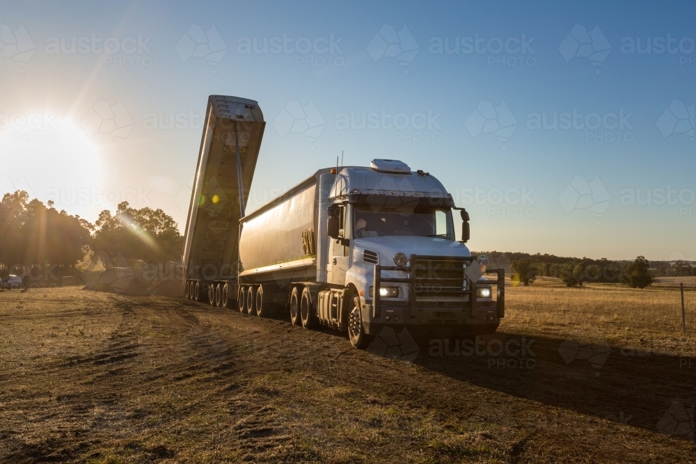 Road train offloading fertiliser on a farm - Australian Stock Image