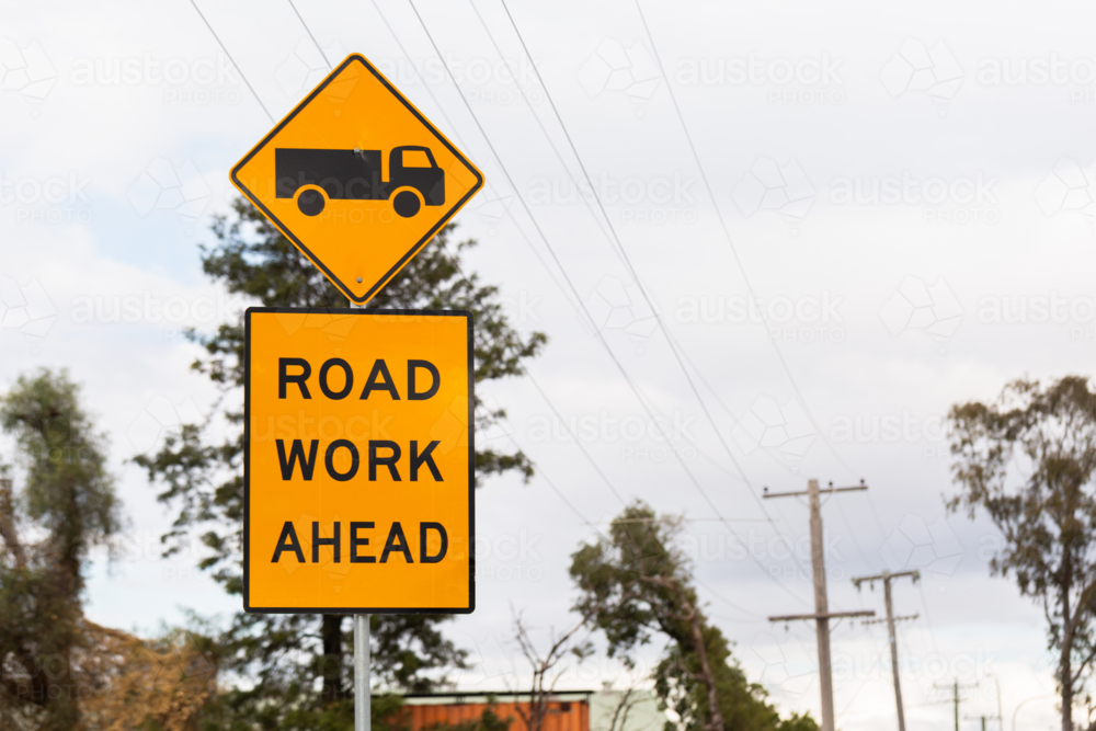 road work ahead signage on overcast day with truck on sign - Australian Stock Image