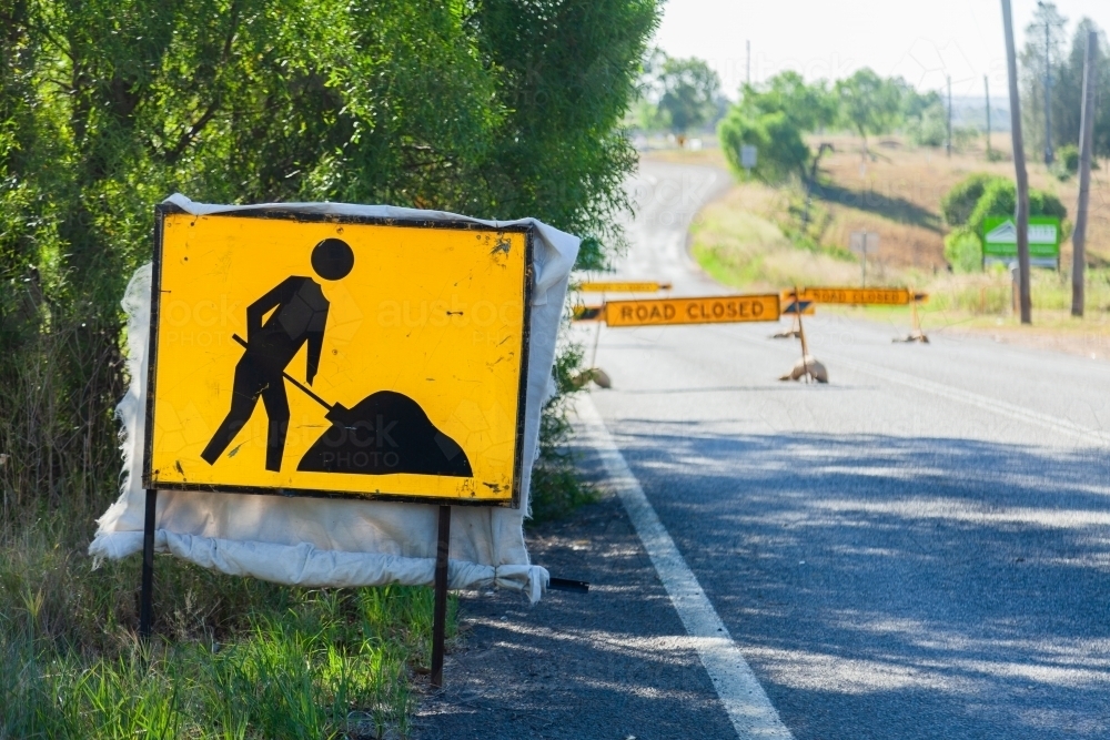 Roadwork sign of person digging hole and road closed signs - Australian Stock Image