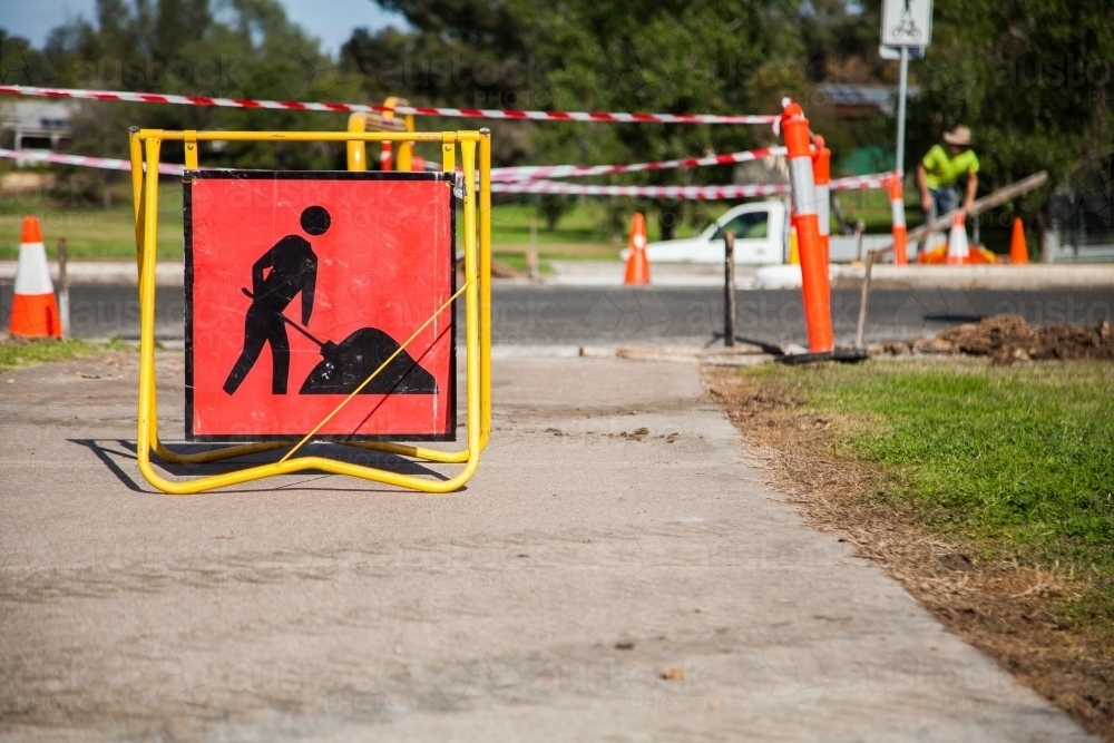 Roadwork sign on footpath before taped off work-site area - Australian Stock Image