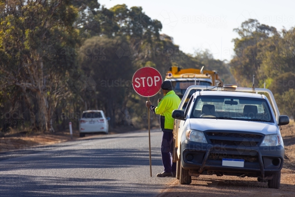 roadworker near work ute with stop sign - Australian Stock Image