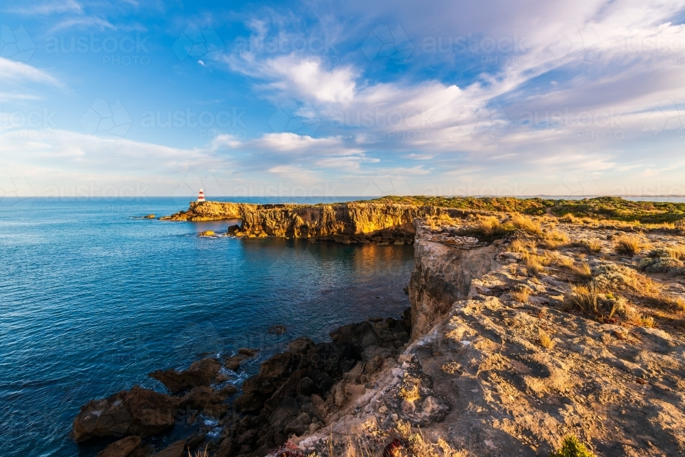 Robe Obelisk viewed along the rugged Limestone Coast with the ocean at sunrise. - Australian Stock Image