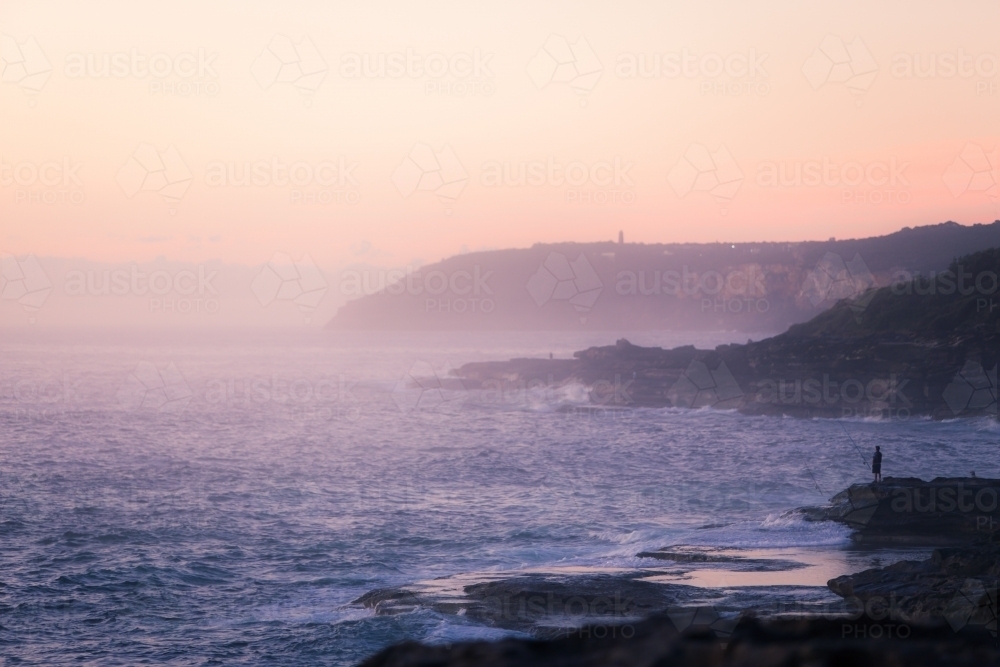 Rock fishing at sunrise - Australian Stock Image