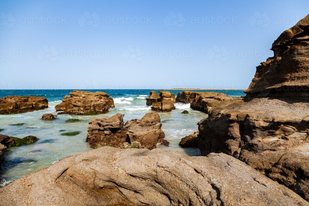 Rock formations with the ocean swirling out with the tide - Australian Stock Image