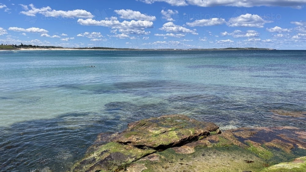 Rock platform and Bate Bay on a sunny day - Australian Stock Image