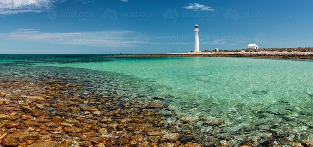 rocky bay with lighthouse and outbuildings - Australian Stock Image