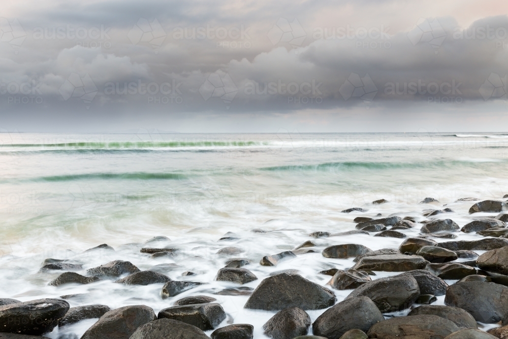 Rocky coastline looking out to a storm at sea - Australian Stock Image