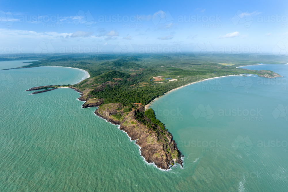 Rocky headland and sweeping tropical coastline from the air. - Australian Stock Image