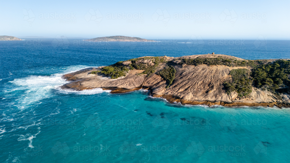 Rocky island surrounded by turquoise waters - Australian Stock Image