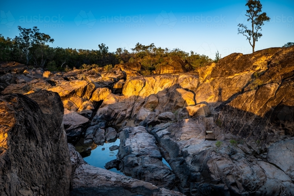 Rocky river and waterhole at sunrise - Australian Stock Image