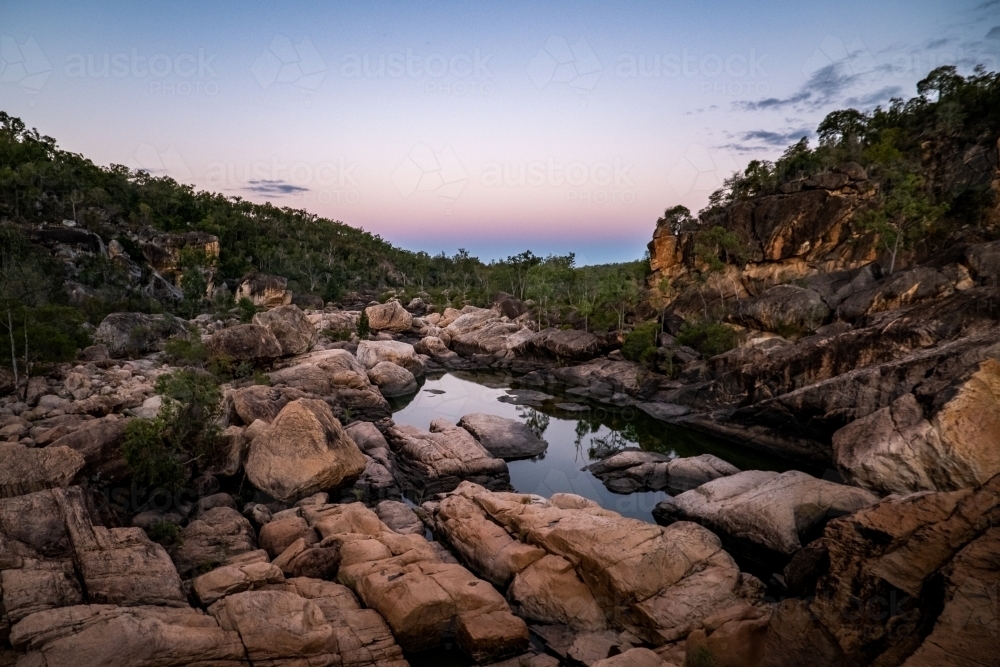 rocky waterhole and river after sunset - Australian Stock Image