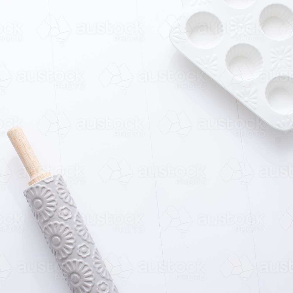 Rolling pin and muffin dish on blank background - Australian Stock Image