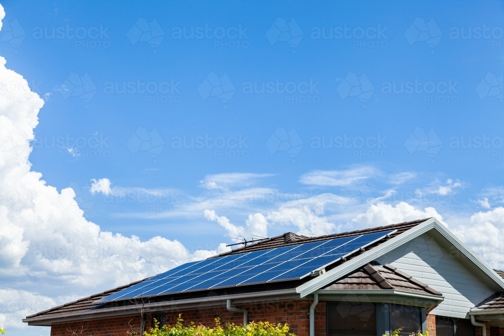 Roof filled with solar panels and big blue sky with copy space - Australian Stock Image