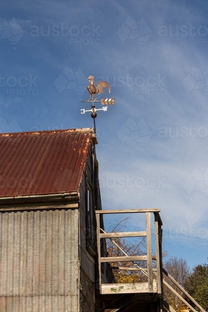 Rooster weather vane on old barn roof - Australian Stock Image
