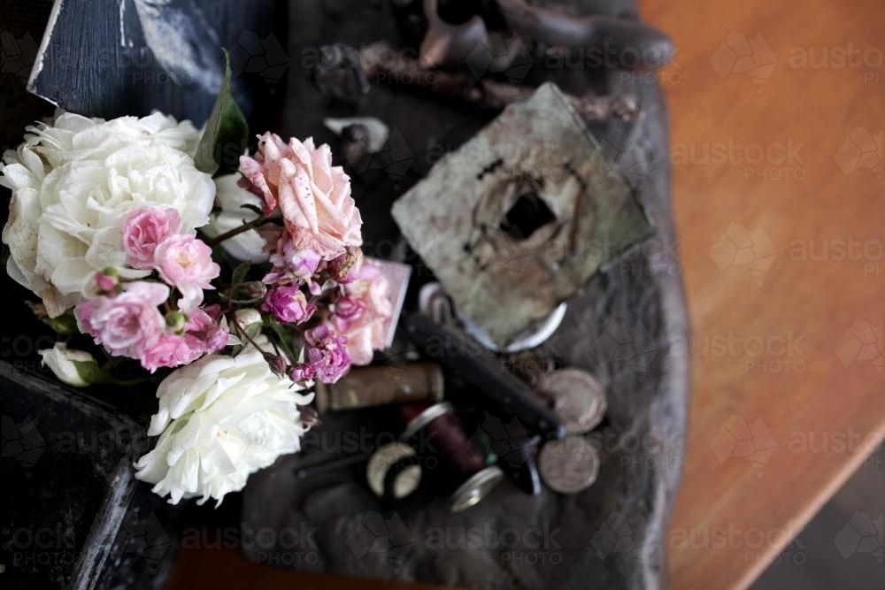 Roses and vintage decorations on a table from above - Australian Stock Image
