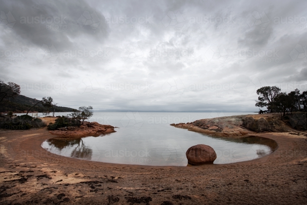 Round shaped bay with stormy sky reflections - Australian Stock Image