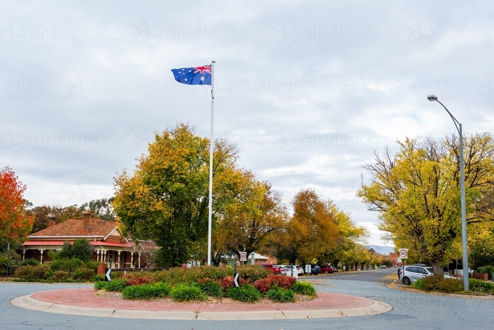 Roundabout with australian flag flying in autumn street scene - Australian Stock Image