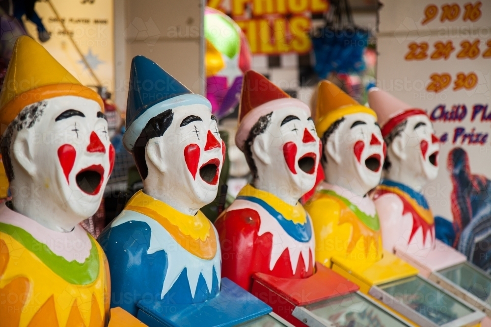 Row of brightly coloured clown heads turning - Australian Stock Image