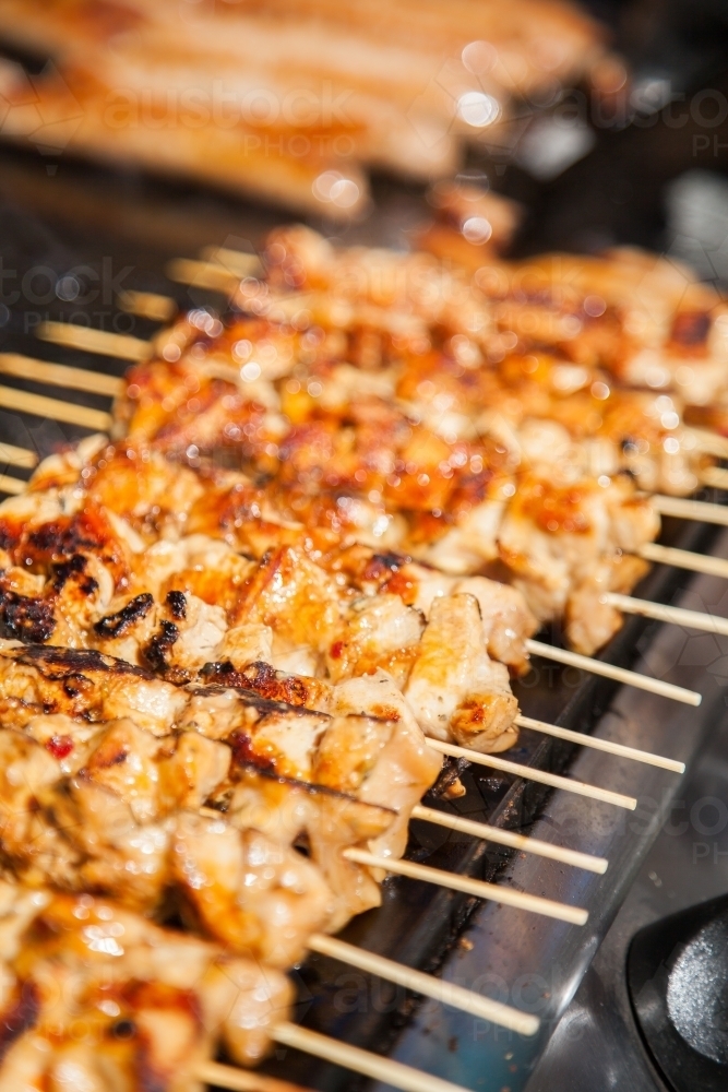 Row of chicken kebabs cooking on the barbecue - Australian Stock Image