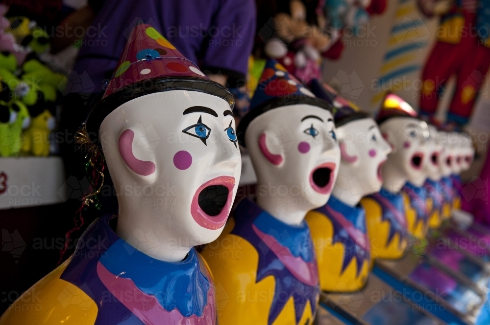 Row of clown heads, turning towards camera - Australian Stock Image