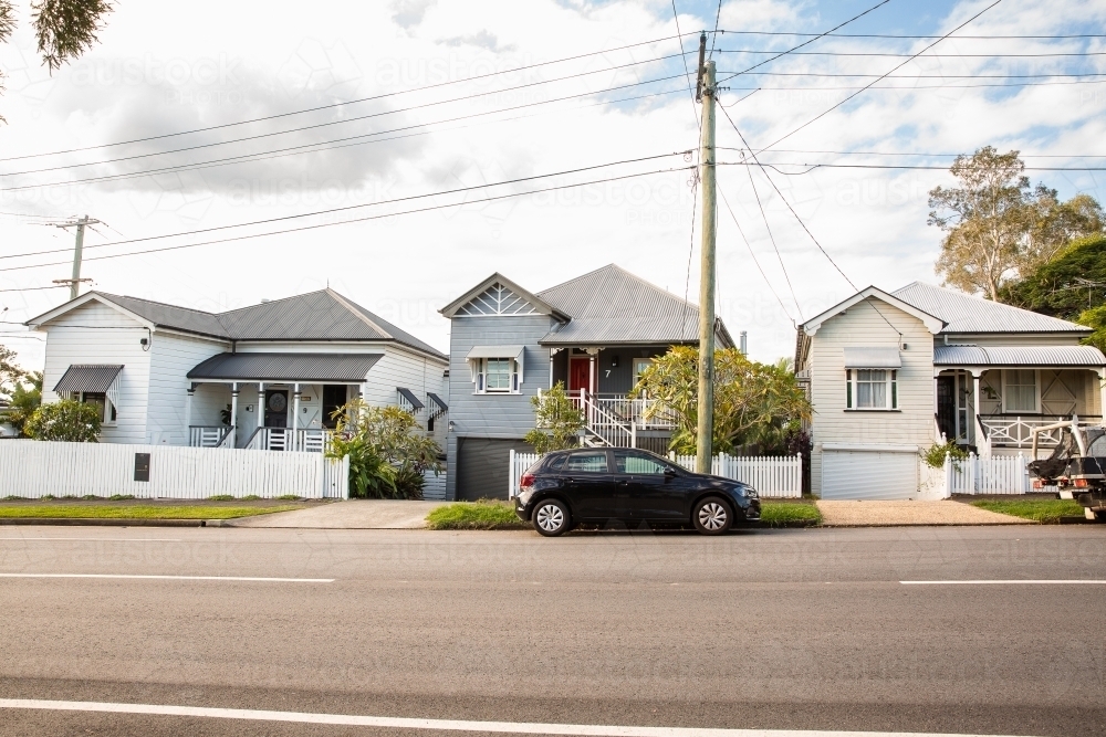 row of cottages on a Brisbane street on a sunny day - Australian Stock Image