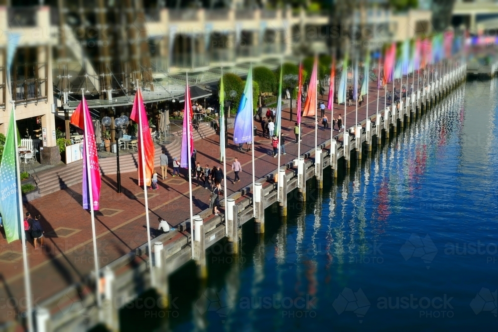 Row of flags along edge of water with reflections Darling Harbour, Sydney - Australian Stock Image