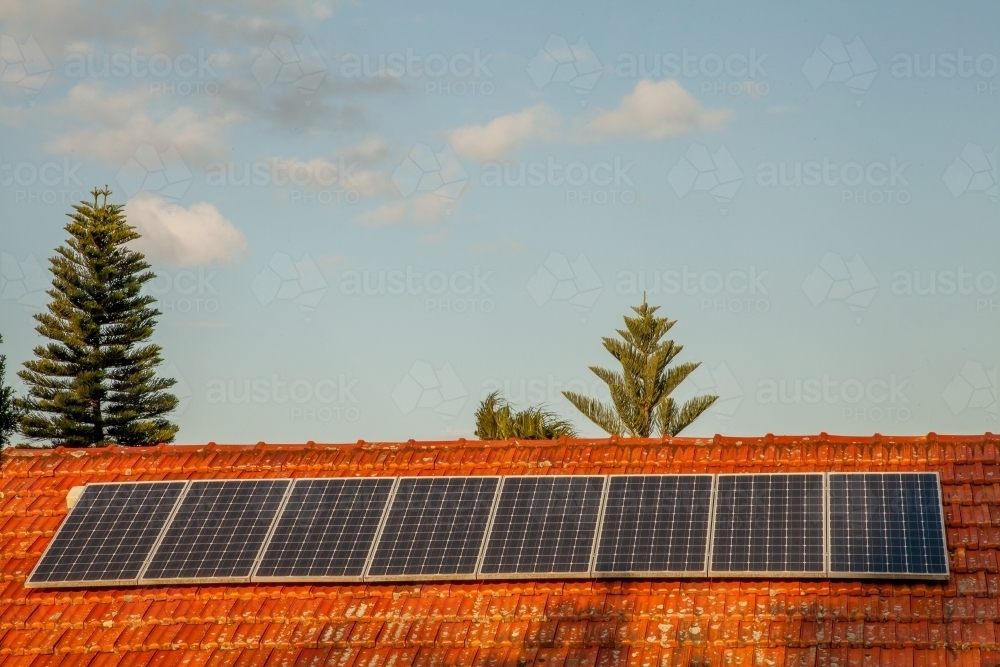 Row of solar panels on red tiled roof - Australian Stock Image